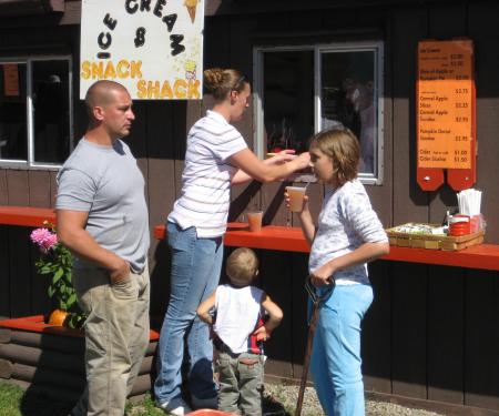 Family about to enjoy some apple cider at Pumpkinville